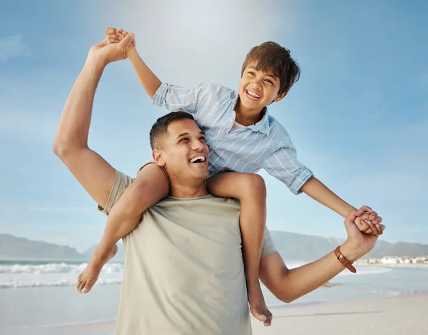 Father, child on beach with piggy back, smile and playing together in summer waves on tropical island holiday. Fun, dad and boy on ocean vacation with love, support and relax with blue sky in Hawaii