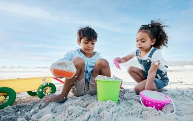 Oğlan, kız ve kovayla kürek, kumsal kumu ve oyun için kazı, yazın açık hava ve tatil. Çocuklar, kardeşler ve plastik oyuncaklar kumdan kale, inşaat oyunu ve deniz kenarında tatilde.