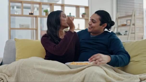 爆米花 嬉闹和夫妻在家里沙发上的结合 健康的关系和幸福 快乐的男人和女人一起在客厅里吃零食 谈恋爱 — 图库视频影像
