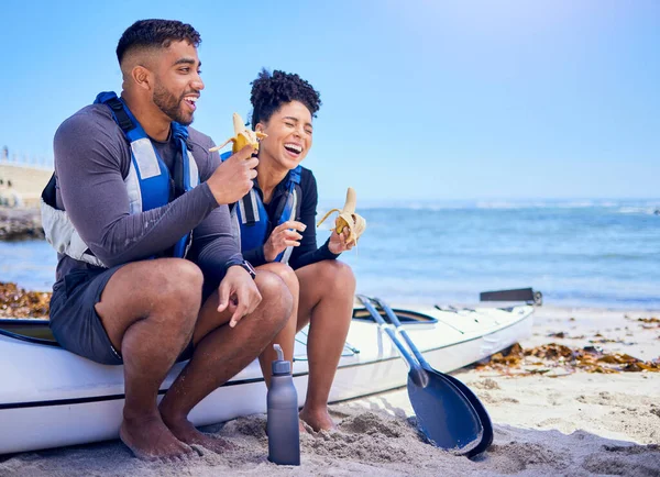 カヤック カップル ビーチでバナナを食べる 面白くて モックアップスペースで一緒に結合 海でボートでフルーツ スポーツをカヌーし フィットネス 健康的な体で幸せ — ストック写真