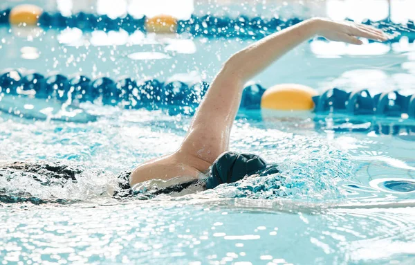 Swimming pool, water splash and sports person training for game challenge, fitness or performance workout. Swimmer action, liquid and wet athlete cardio, race competition or practice freestyle stroke.