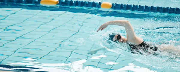 Sports, swimming and woman athlete training for a race, competition or tournament in a pool. Fitness, workout and female swimmer practicing a cardio water skill for exercise, speed or endurance
