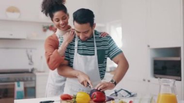 Kucaklaşma, yemek ve evlilik yıldönümlerinde romantik bir yemek için evlerinin mutfağında yemek pişirme. Bir evde sebze hazırlayan mutlu bir erkek ve kadınla aşk, sağlık veya beslenme..