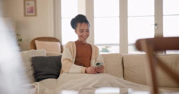 年轻的女人 在沙发上打电话和放松 在家里客厅里思考问题 发短信 上网聊天或写博客 带着滚动 迷因或社交媒体应用在沙发上的兴奋的微笑和智能手机 — 图库视频影像