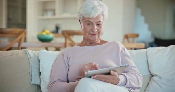 在社交媒体 移动应用程序或互联网上 客厅里沙发上的放松 平板电脑和老年女性在滚动 上网和老年女性在家里的休息室用技术浏览网站 — 图库视频影像