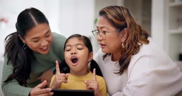 母亲和女孩一起坐在平板上 就像一家人在客厅里玩游戏一样 教育或上网 由年长的妇女和女儿在网上教孩子 — 图库视频影像