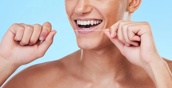 ハッピーマン 歯のフロス 口腔衛生の歯をきれいにする または青いスタジオの背景に対してグルーミング フロスティング 歯のホワイトニング マウスケアで大きな笑顔を持つ男性のクローズアップ — ストック写真
