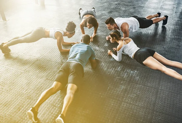 People, fitness and push up in class, group or circle for workout, training and community support. Exercise team, friends and athlete in gym for lose weight, sports and health or accountability above.