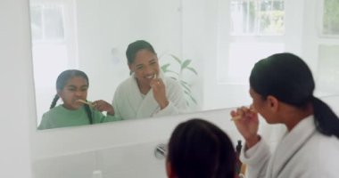 Anne, mutlu ya da banyodaki çocuk aile evindeki aynada ağız temizliği için dişlerini fırçalıyor. Çocuk gelişimi, komik anne ya da diş sağlığı için diş fırçasıyla ağız temizleyen kız.