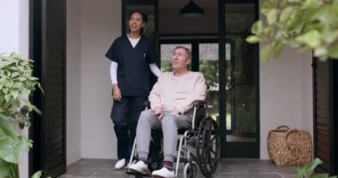 Tekerlekli sandalyedeki yaşlı adam, bahçe ya da huzur evinde sağlık desteği için konuşan mutlu bir bakıcı. Gülümseyin, temiz hava alın ya da yaşlı ya da engelli bir hastayla konuşun..