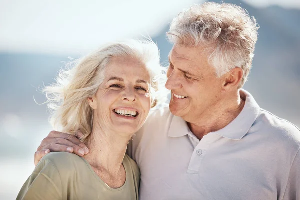 Senior couple, laughing and outdoor at beach with happiness, freedom and care on vacation. Face of a man and woman on retirement holiday, adventure and romantic trip in nature to relax and travel.