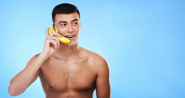 ゴシップ または面白い議論のためのスタジオで電話 バナナ 若い男 カナダのハッピー コミュニケーション 男性モデル ブルーバックグラウンドでモックアップスペース — ストック写真