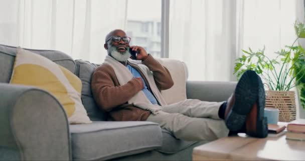 ソファーでリラックス シニアマン ネットワークとのつながり アフリカの人 携帯電話を持つ家と年金 リビングルームで話すか退職 — ストック動画