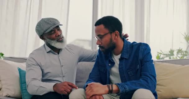 和他的老父亲在客厅的沙发上进行对话 聊天室的舒适和男人的心理健康 年轻的非洲男性在家中的休息室里与年迈的父亲交谈 寻求支持 — 图库视频影像