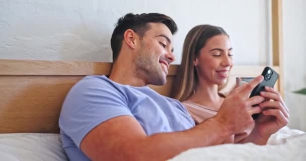 在社交媒体 移动应用或互联网上 打电话 在床上放咖啡 爱你的 快乐的 年轻的男人和女人在家里的卧室里喝着拿铁 用手机浏览 — 图库视频影像