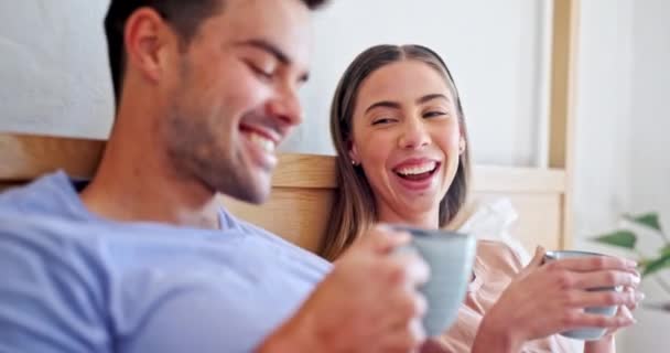 コーヒー 若いカップルは 週末の朝に一緒に結合するためにベッドで カナダ出身のハッピー 若い男女 リラックスして現代の家の寝室でラテを飲む — ストック動画