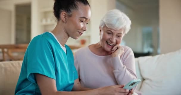 老年妇女和护士在沙发上 智能手机和打字连接 网络和社交媒体 可在线阅读的沙发 手机和移动应用程序上的人 老年人和护理人员 — 图库视频影像