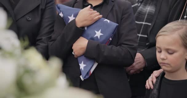 および敬意 儀式および追悼のためのベテランのためのアメリカの旗を持つ女性 兵士のための墓地の棺で家族 うつ病 悲しい人々 — ストック動画