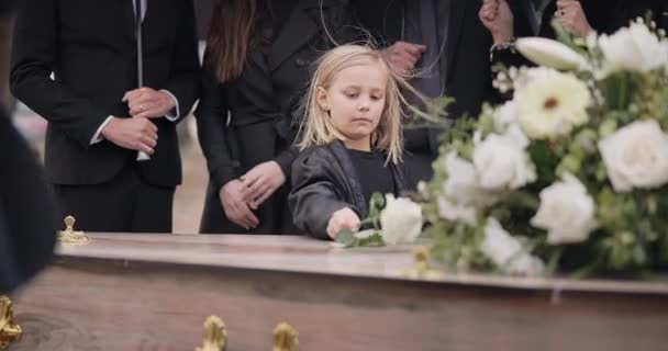 葬礼上的死亡 悲伤和女孩 棺材上放着鲜花 家人和悲伤的孩子在墓地服侍 以求得尊重 失落和公墓的木箱里的人 孩子在坟墓里哭着下葬 — 图库视频影像