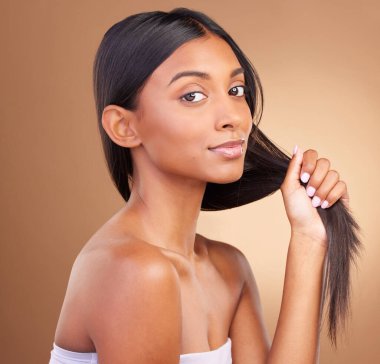 Portre, kadın ve keratin tedavisi için stüdyoda saç büyümesi, şampuan kozmetiği ve kahverengi arka planda temiz dermatoloji. Hint modeli, doğal güzellik ve ışıltılı güçlü saç stili..