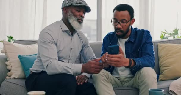 スマートフォン ソーシャルメディアとの接続 家庭や質問を持つネットワーク 父親と息子 黒人男性 または携帯電話 モバイルアプリで助けたり 電子メール通知で学習したり — ストック動画