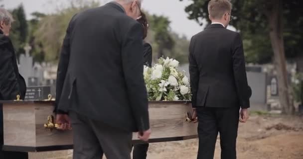 男人和传道士在墓园外的墓葬前散步 坟场的死亡 悲伤和集体丧葬 在大风中举行的丧礼和为人们的家人服务 — 图库视频影像