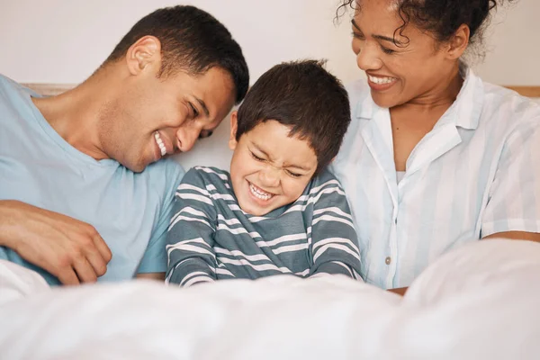 Happy, tickle and funny with family in bedroom for playful, morning and love. Care, support and wake up with parents and boy child laughing in bed at home for weekend, positive and relax together.