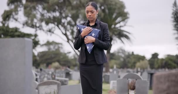 死亡还有一个悲伤的女人拿着美国国旗在墓地参加追悼会悲伤 美国人和一个军人妻子 就像一个寡妇 独自在坟墓里 感受着失去或悲伤的痛苦 — 图库视频影像