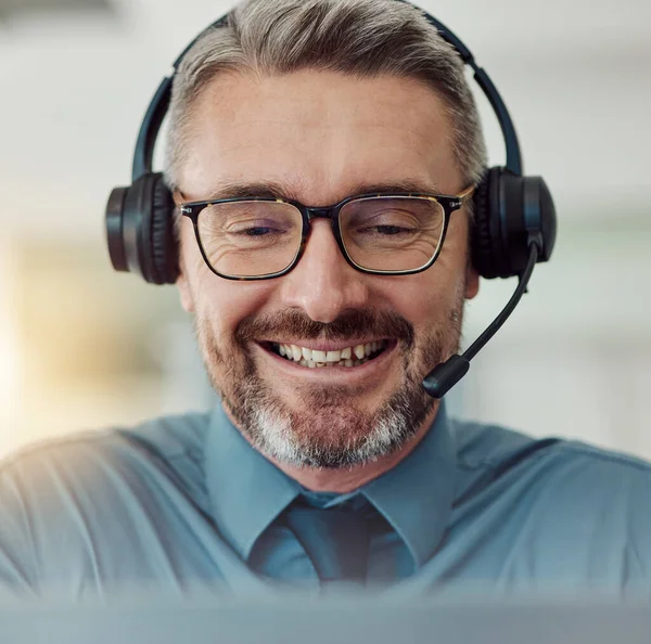 Senior, happy man and face in call center with headphones in customer service, support or telemarketing at office. Mature businessman, consultant or agent smile in online advice, help or contact us.
