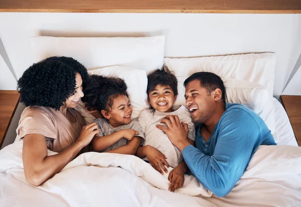 おかしな人 子供たちは 幸せな両親と一緒に朝のベッドで笑っています 上からの週末の結合のための寝室の母親 父親および子供とのリラックス 愛または笑顔 — ストック写真