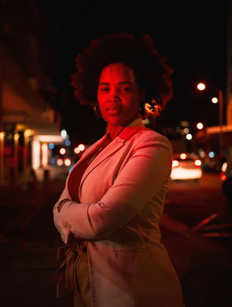 Portrait of black woman, city and night lights, standing in dark street and waiting for taxi with bokeh. Urban business fashion, late travel in Africa and serious girl in road with neon red lighting
