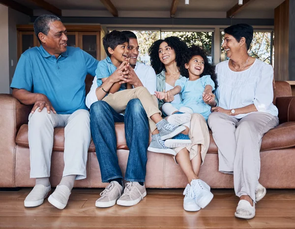 Smile, funny and relax with big family on sofa for happy, bonding and peace. Love, generations and grandparents with parents and children in living room at home for vacation, cuddle and embrace.