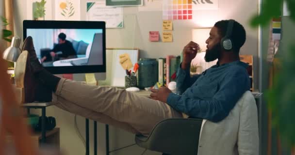 コンピュータ ウェブシリーズ オフィスのスナックや食べ物で映画を見ている男 リラックス インターネットとアフリカの男性 フィルムサブスクリプションアプリとヘッドフォンでオンラインビデオを聞く — ストック動画