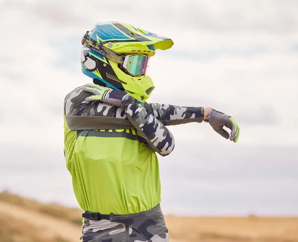 Motor sports, stretching and man with helmet in nature for training, workout and performance for race. Travel, motorbike and person outdoors ready for action for adventure, freedom and adrenaline.