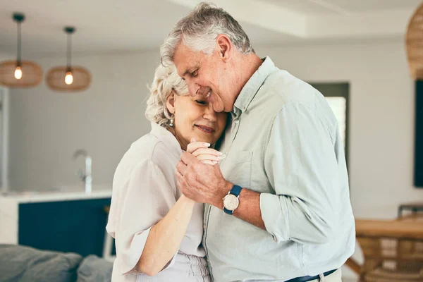 Holding hands, hug or happy old couple dancing for love, support or trust in marriage at home together. Smile, romantic elderly man or senior woman bonding with care in retirement in the living room.