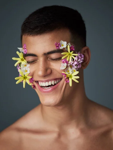 Face, happy man and flowers, beauty and nature, cosmetics and headshot with art deco isolated on studio background. Natural aesthetic, dermatology with eco friendly skincare and clean with spring.