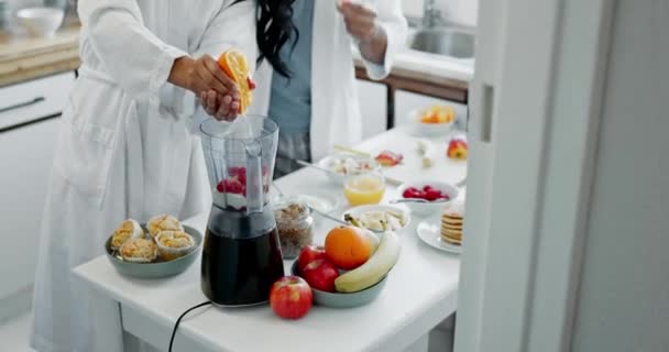 朝のビタミンCや栄養のためのオレンジ色のブレンダーのカップル 手と果物 人々または家庭でフルーツと機械でタンパク質の揺れをブレンドする — ストック動画