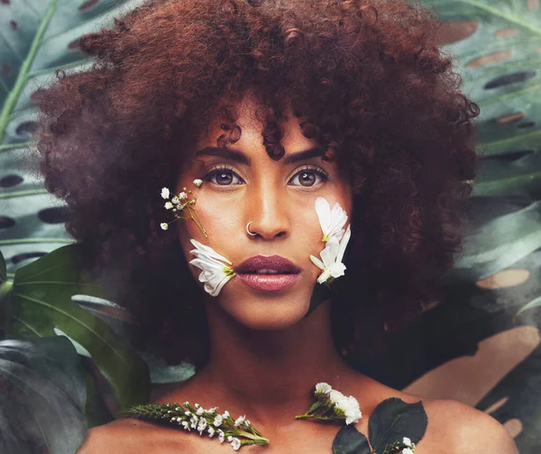Flowers, art and portrait of black woman with beauty, skincare and creative or eco friendly cosmetics from nature. Natural, face and model with flower makeup and healthy organic skin care in forest.