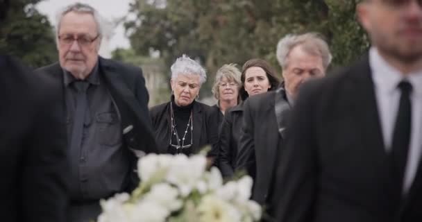 抬着棺材的人 抬着棺材参加葬礼 仪式或哀悼活动的人 带着悲伤 悲伤和鲜花在墓地走着 与家人一起参加追悼会的人 支持和步行 — 图库视频影像
