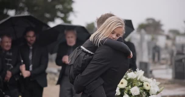 拥抱和一个父亲和一个孩子在坟墓与一群人一起参加葬礼和哀悼 年轻的和一个关心和爱一个女孩的爸爸一起在墓地的葬礼和悲痛 — 图库视频影像