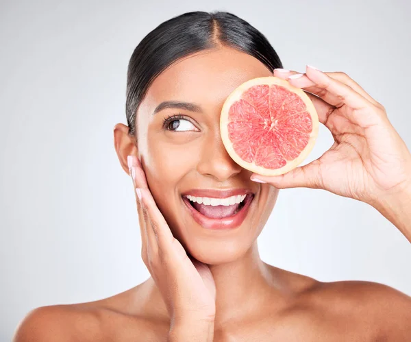 Grapefruit, excited and woman with fruit, beauty and facial with natural skincare isolated on white background. Wellness, vegan cosmetic product and glow, shine and vitamin c with citrus in studio.