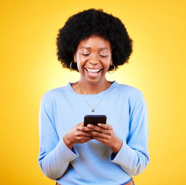 Kadın, stüdyoda akıllı telefondan gülümse ve daktilo et, sosyal medyayı oku ve sarı arka planda komik bir mim oku. Mutlu Afrika modeli, cep telefonu ve indirme oyunları, flört uygulaması veya multimedya bildirimi.