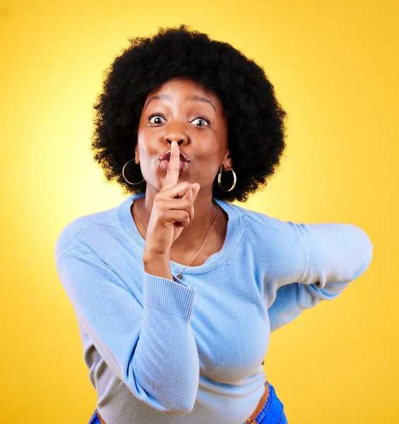 Secret, portrait and black woman with finger on lips in studio for privacy, drama and surprise on yellow background. Model, quiet emoji and whisper for gossip, trust and confidential mystery news.