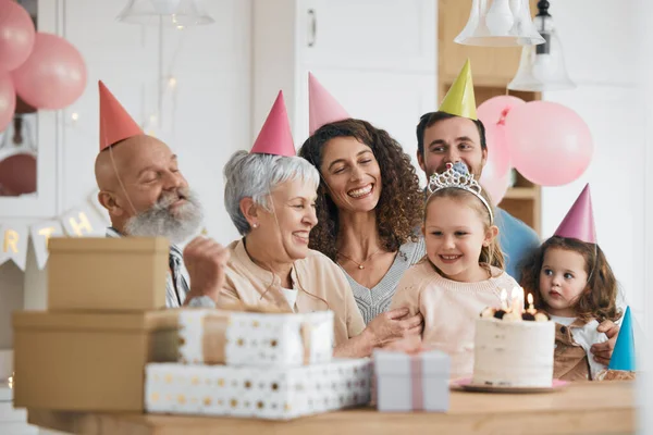 Happy birthday, gift and big family celebrate with cake in a home party, event and candles in a house together. Mother, father and grandparents excited for surprise gathering with children or kids.