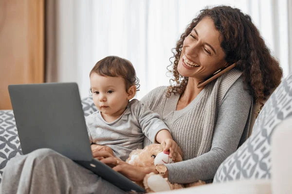 Laptop, baby or mom on a phone call to relax in home sofa in conversation or communication. Smile, multitasking or happy single parent laughing, talking or speaking on mobile with a child or kid.