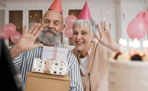 Happy birthday, video call and senior couple celebrate with cake in a home party, event and candles in a house together. Man, woman and elderly excited for virtual or remote surprise on retirement.