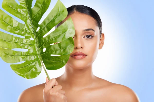 Woman with palm leaf, portrait and natural beauty with sustainable skincare isolated on white background. Wellness, skin glow and eco friendly cosmetics with green product, nature and face in studio.