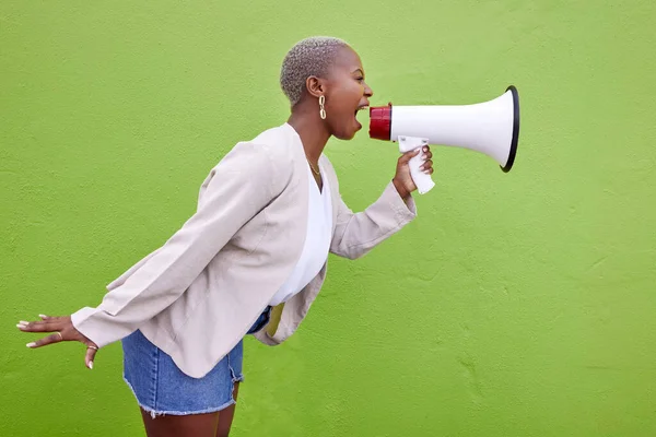 Black woman, megaphone and protest on mockup space in advertising or voice against a studio background. African female person screaming in bullhorn or shouting for sale discount, vote or alert.