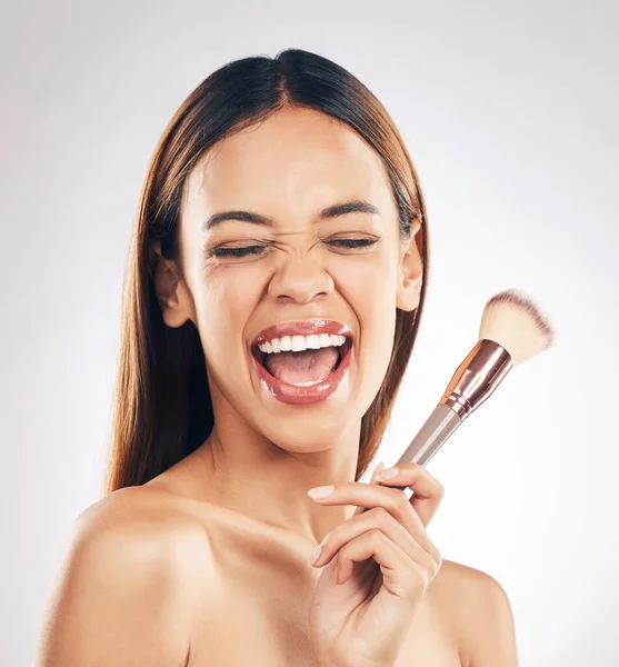 Woman, excited with brush for makeup, beauty and happiness with foundation isolated on white background. Powder, cosmetics tools and skincare with shine, positivity and smile for skin glow in studio.