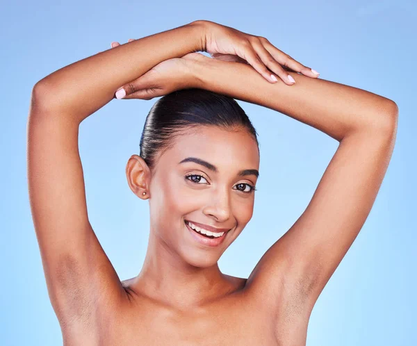 Armpit, hair removal and woman in portrait with beauty, grooming and smile isolated on blue background. Hygiene, cleaning body and epilation with skincare, cosmetics and dermatology in a studio.